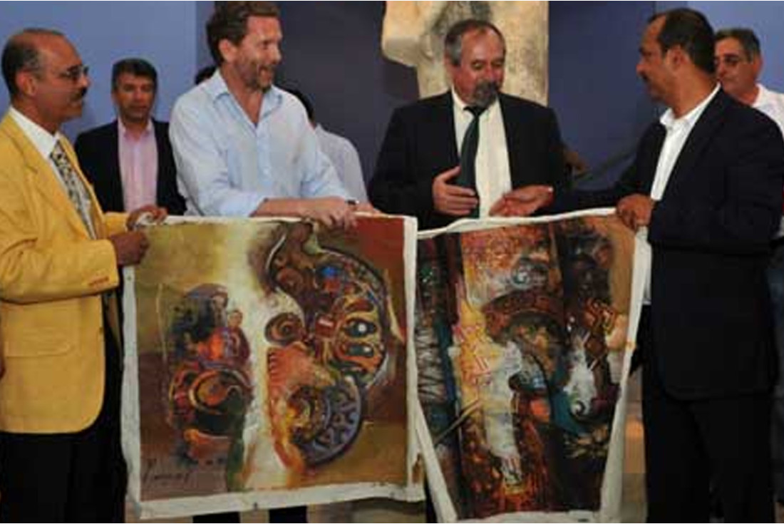 Almosawi presenting Greek Minister of Culture Pavlos Geroulanos two paintings